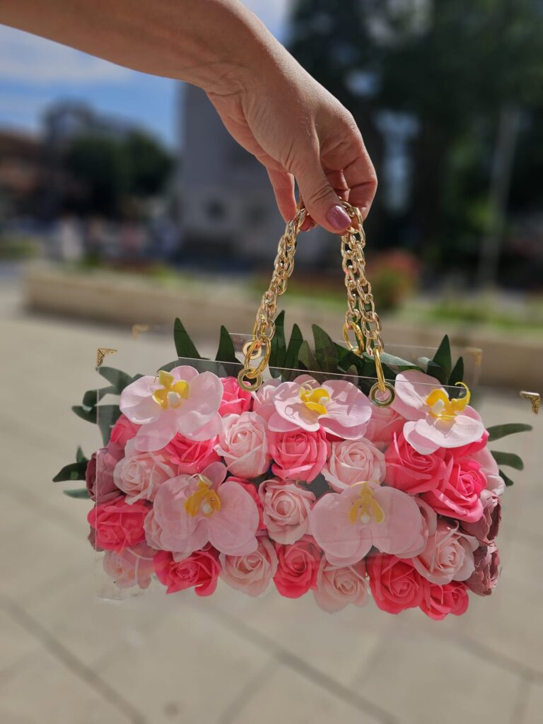 Meta Title SEO Geantă Acrilică cu Trandafiri, Orhidee și Camelia din Săpun | Cadou Premium | Royal Flowers Constanța Meta Description Descoperă geanta acrilică premium decorată cu trandafiri roz, orhidee și camelia din săpun parfumat. Un cadou elegant și de lungă durată, realizat manual de Royal Flowers Constanța. Ideal pentru aniversări, 8 Martie, Valentine's Day și alte ocazii speciale. H1 Geantă Acrilică Premium cu Trandafiri, Orhidee și Camelia din Săpun Un cadou exclusivist care îmbină eleganța florilor cu frumusețea unui accesoriu de lux Surprinde persoana dragă cu un cadou deosebit, creat pentru a impresiona și a rămâne o amintire prețioasă. Geanta Acrilică Premium cu Trandafiri, Orhidee și Camelia din Săpun este o creație florală exclusivă, realizată manual în atelierul Royal Flowers Constanța, unde fiecare detaliu este atent lucrat pentru a oferi un produs elegant și sofisticat. Realizată din acril transparent de înaltă calitate, geanta este decorată cu trandafiri roz, flori de orhidee și o camelia, toate confecționate din săpun parfumat premium. Aspectul lor delicat reproduce fidel frumusețea florilor naturale, iar parfumul discret completează experiența acestui cadou special. Designul este pus în valoare de mânerele metalice aurii și de aranjamentul floral bogat, transformând geanta într-o piesă decorativă luxoasă, potrivită atât pentru a fi oferită în dar, cât și pentru a decora elegant orice încăpere. Compoziție Trandafiri roz din săpun parfumat Flori de orhidee din săpun parfumat Floare de camelia din săpun parfumat Frunziș decorativ premium Geantă din acril transparent Mânere metalice aurii Design realizat integral manual Compoziția poate varia ușor în funcție de disponibilitatea materialelor, păstrând întotdeauna stilul, cromatica și valoarea produsului. Semnificația florilor 🌸 Trandafirii roz simbolizează iubirea, tandrețea, admirația și recunoștința. 🌺 Orhideea este simbolul eleganței, feminității, frumuseții rafinate și al luxului. Ea exprimă apreciere, respect și sentimente sincere. 🤍 Camelia reprezintă perfecțiunea, rafinamentul și dragostea profundă, fiind una dintre cele mai elegante flori utilizate în aranjamente premium. Împreună, aceste flori creează un cadou sofisticat, plin de simbolism și emoție. Avantajele florilor din săpun Florile din săpun sunt o alternativă elegantă la florile naturale, păstrându-și frumusețea pentru foarte mult timp. Beneficii Nu se ofilesc. Nu necesită apă sau întreținere. Își păstrează forma și culoarea ani la rând. Au un parfum discret și plăcut. Pot fi folosite ulterior ca obiect decorativ. Reprezintă un cadou elegant și original. Caracteristici Geantă acrilică transparentă premium Flori realizate integral din săpun parfumat Design exclusivist Produs handmade Mânere metalice aurii Aspect luxos și elegant Cadou decorativ de lungă durată Ambalare premium inclusă Ideală pentru ❤️ Ziua Îndrăgostiților ❤️ Dragobete ❤️ 8 Martie ❤️ Ziua Mamei ❤️ Zi de naștere ❤️ Onomastică ❤️ Aniversare ❤️ Cerere în căsătorie ❤️ Cadou pentru iubită ❤️ Cadou pentru soție ❤️ Cadou pentru mamă ❤️ Cadou pentru fiică ❤️ Cadou corporate Îngrijire Pentru a menține frumusețea aranjamentului floral: evitați contactul direct cu apa; păstrați produsul într-un loc uscat și răcoros; evitați expunerea îndelungată la lumina directă a soarelui; curățați geanta din acril cu o lavetă moale și uscată; manipulați florile cu grijă pentru a le păstra aspectul impecabil. Royal Flowers Constanța La Royal Flowers Constanța, realizăm cadouri florale premium și aranjamente unice, create pentru a transforma orice ocazie într-un moment memorabil. În atelierul nostru găsești buchete elegante, geanți florale din acril, aranjamente cu flori din săpun, flori criogenate, decoruri pentru evenimente și cadouri personalizate, toate realizate cu pasiune și atenție la detalii. Livrare rapidă în Constanța Poți comanda această geantă acrilică cu trandafiri, orhidee și camelia din săpun direct de pe www.royalflowers.ro sau din florăria noastră din Constanța. Asigurăm livrare rapidă în Constanța și împrejurimi, iar fiecare produs este ambalat cu grijă pentru a ajunge în condiții perfecte. URL recomandat https://www.royalflowers.ro/geanta-acrilica-trandafiri-orhidee-camelia-din-sapun SEO Title alternativ Geantă Acrilică cu Trandafiri, Orhidee și Camelia din Săpun | Royal Flowers Constanța Alt Text Imagine Geantă acrilică transparentă cu trandafiri roz, orhidee și camelia din săpun parfumat, realizată manual de Royal Flowers Constanța, cadou premium pentru ocazii speciale. Cuvinte cheie SEO geantă acrilică cu flori din săpun, geantă cu trandafiri din săpun, geantă cu orhidee din săpun, geantă cu camelia din săpun, flori din săpun Constanța, aranjament cu flori din săpun, geantă florală premium, cadou elegant Constanța, cadou pentru femei, cadou aniversare, cadou Valentine's Day, cadou 8 Martie, florărie Constanța, Royal Flowers Constanța, cadouri premium, cadouri personalizate, livrare flori Constanța, geantă transparentă cu flori.